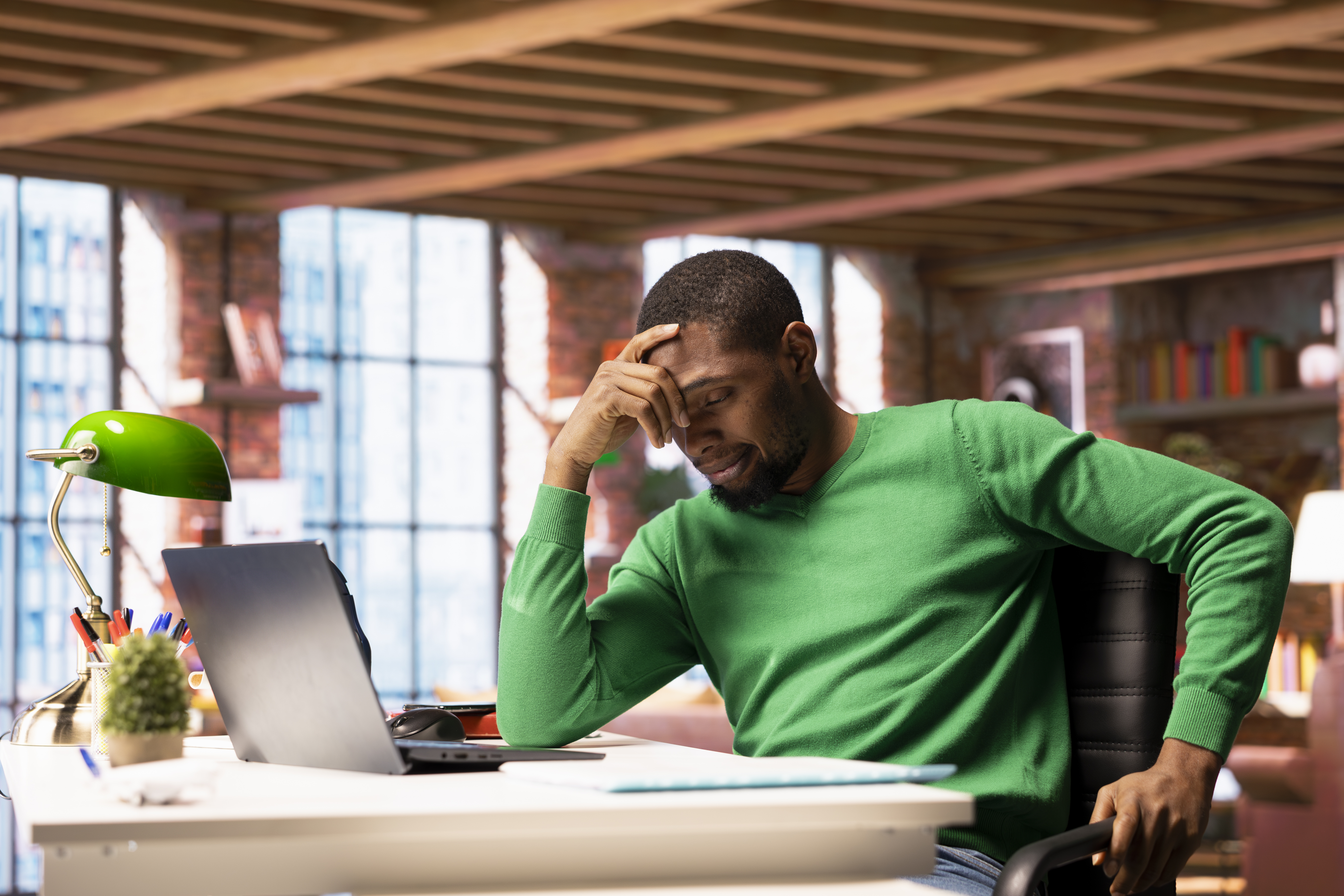 Focused man using a laptop to automate tasks in a modern workspace.