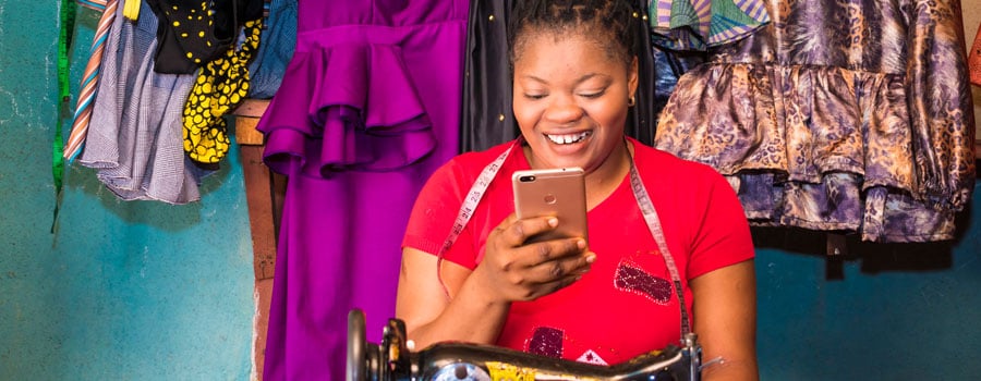 A fashion designer happily checking messages on her phone